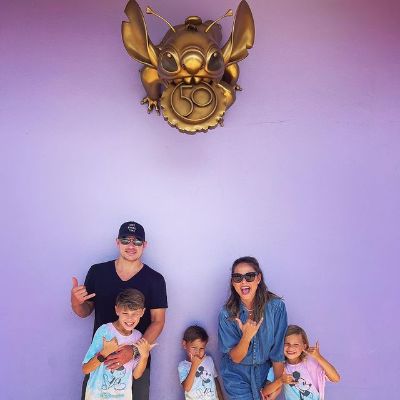 Nick, Vanessa, Camden, Brooklyn, and Phoenix Lachey are posing as the Stitch character is hanging above them.